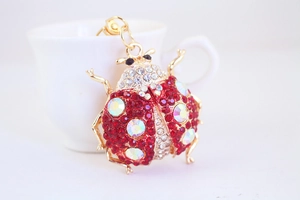 Macro view of the sparkling red rhinestone ladybug pendant with detailed gold metal hinge