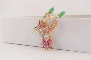 Vue détaillée du porte-clés colibri avec émail rose dégradé et cristaux brillants
