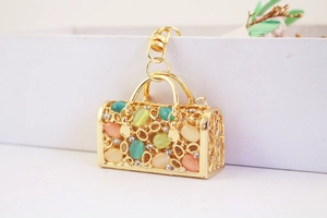 Detail of creative hollow metal handbag charm with colorful oval faux gemstones and lobster clasp