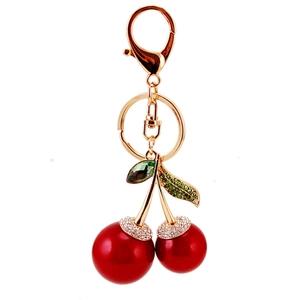 Sparkling cherry keychain with red faux pearls and green rhinestone leaves on gold chain