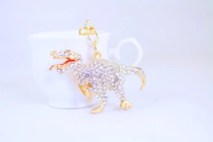 Detailed macro view of gold dinosaur keychain with crystal rhinestones on a white cup