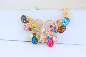 Macro di portachiavi a farfalla dorata con strass colorati e cristalli a goccia
