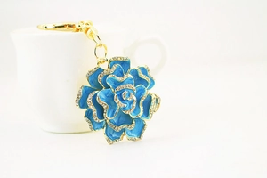 Detailed close-up of blue enamel rose keychain with sparkling rhinestones and gold plating