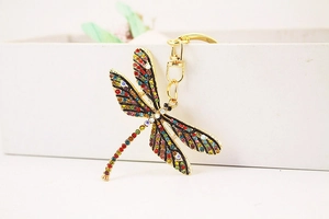 Detailed macro view of gold dragonfly keychain wings with colorful vibrant rhinestones