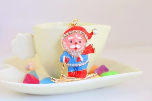 Macro shot of skiing Santa Claus keychain with colorful enamel and sparkling rhinestones