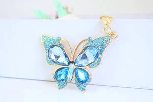 Macro detail of butterfly keychain featuring light blue crystals and gold alloy base