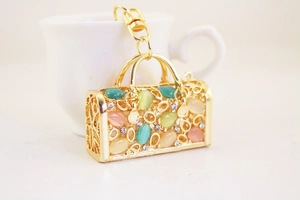 Detailed view of hollow handbag keychain with colorful cat eye stones and small rhinestones