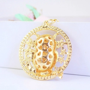 Vue détaillée du pendentif fleur et cacahuète doré avec motifs en forme de cœur
