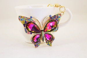 Macro shot of colorful butterfly keychain with pink crystals and micro-diamond accents