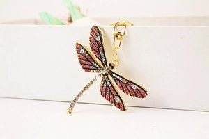 Close-up of golden dragonfly keychain with sparkling pink and purple rhinestones