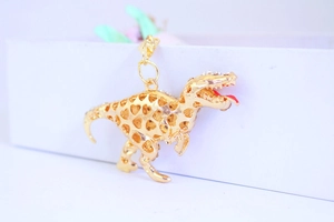 Detail of gold dinosaur keychain with hollow heart design and sparkling rhinestones