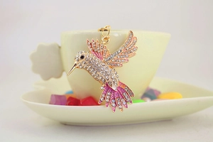 Gros plan du porte-clés colibri orné de strass et d'ailes en émail violet et rose