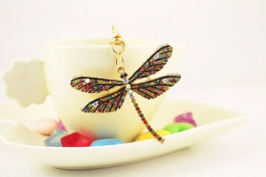 Close-up of a colorful dragonfly keychain with sparkling crystals and gold metal finish