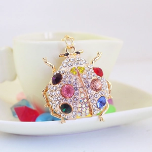 Sparkling ladybug keychain with colorful rhinestones on a polished golden metal base