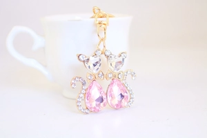Close-up of golden cat keychain featuring pink crystals and sparkling rhinestone details