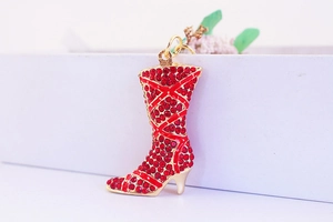 Close-up of red rhinestone encrusted high heel boot pendant with gold metal details