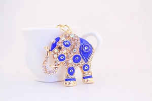 Close-up of golden elephant keychain with blue evil eye enamel and sparkling rhinestones