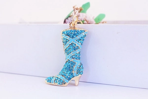 Macro shot of sky blue crystal rhinestone studded gold metal boot pendant accessory