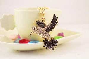 Vue détaillée d'un porte-clés colibri doré étincelant orné de strass brillants