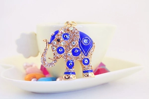 Macro view of blue enamel elephant keychain with crystal devil eye details