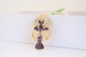 Détail du porte-clés homard doré avec émail violet et incrustation de cristaux