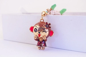 Detailed view of monkey keychain featuring colorful enamel finish and golden metal base