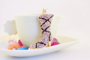 Detailed view of high-heeled boot charm with sparkling rhinestones and black enamel