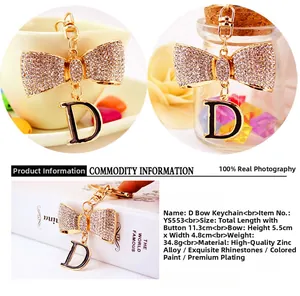 Vue détaillée du nœud en strass et du pendentif lettre D en émail noir avec fermoir doré
