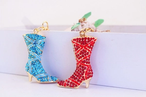 Detailed macro view of colorful rhinestone high heel boot pendants with gold ring