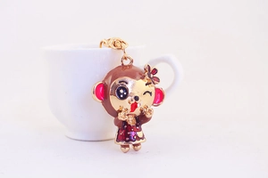 Macro view of a cute monkey charm keychain with red flower and polka dot dress