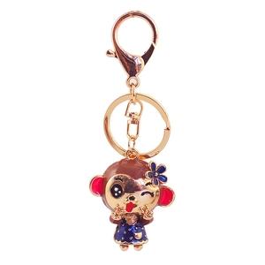 Cute golden monkey keychain with blue floral hat and polka dot dress accessory