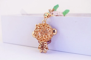 Close-up of golden hollow star cartoon monkey keychain charm with lobster clasp