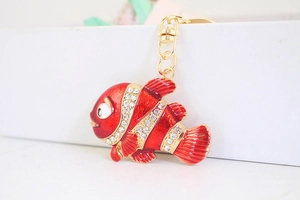 Détail d'un porte-clés poisson-clown rouge en émail avec des strass blancs brillants