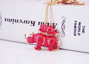 Détail d'un porte-clés rhinocéros en émail rouge avec strass et chaîne dorée