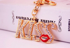 Macro del portachiavi KISS con strass e labbra rosse posizionato su un libro