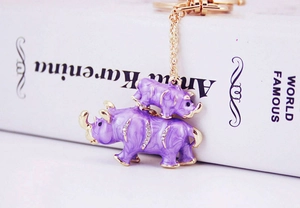 Détail d'un porte-clés rhinocéros en émail violet avec strass brillants et chaîne dorée