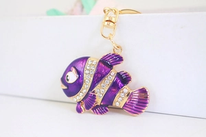 Vue détaillée d'un porte-clés poisson violet avec strass blancs et fermoir rotatif doré