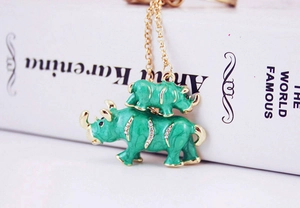 Détails du pendentif rhinocéros en émail vert avec strass brillants sur une chaîne dorée