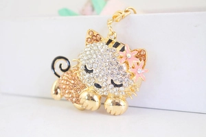 Detailed view of cat keychain with champagne crystals and pink enamel flower accents