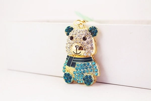 Dettaglio portachiavi a forma di orso dorato con strass incastonati e sciarpa blu