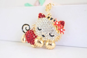 Detail of golden kitten keychain featuring sparkling red and white rhinestones