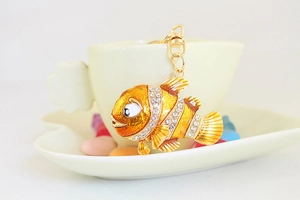Gros plan détaillé d'un porte-clés poisson-clown doré orné de strass blancs brillants