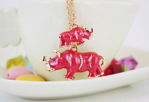 Détail du pendentif rhinocéros en émail rouge avec cristaux sur chaîne dorée