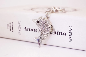 Detailed view of a dolphin keychain with white sparkling crystals on a book background