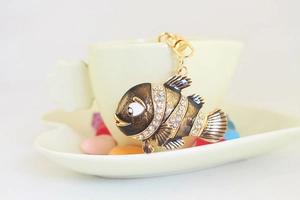 Détail du porte-clés poisson-clown mignon avec finition laque brune et strass blancs brillants