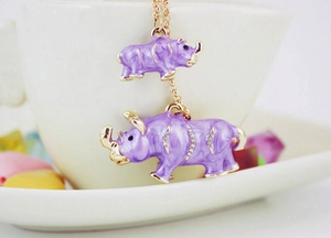 Détail d'un pendentif rhinocéros violet avec cristaux sur une chaîne en métal doré