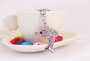 Detailed macro view of crystal dolphin keychain with sparkling white rhinestones on cup