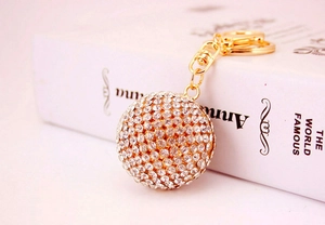 Close-up of luxury crystal ball keychain with gold plating and white rhinestones
