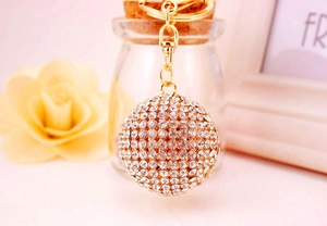 Close-up of a sparkling crystal-studded ball keychain with golden alloy lobster clasp hook