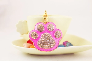 Close-up of bright pink rhinestone cat paw keychain with gold lobster clasp and metal ring